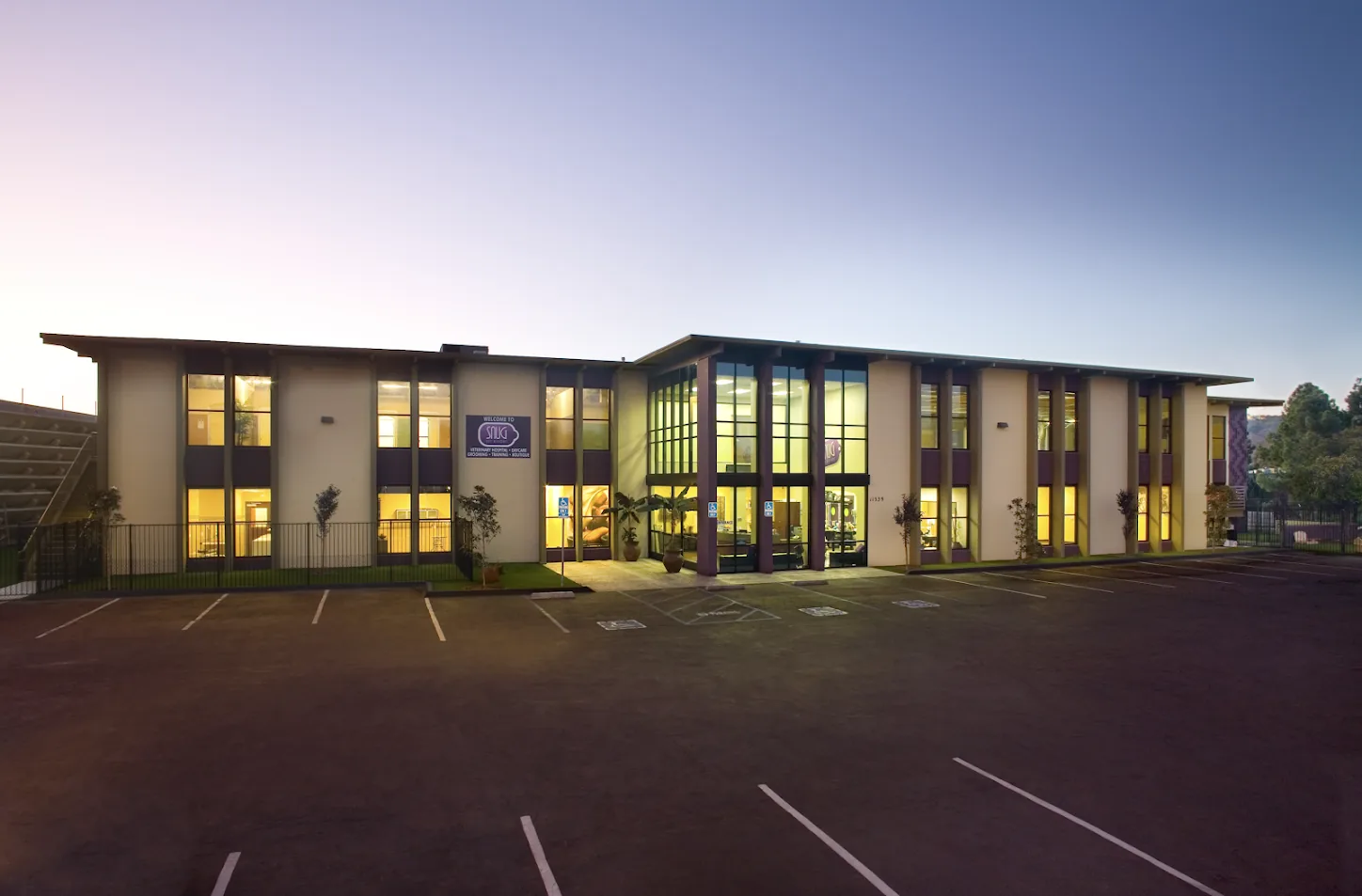 Snug Pet Resort building at dusk in Sorrento Valley, San Diego, with the training and daycare sign lit
